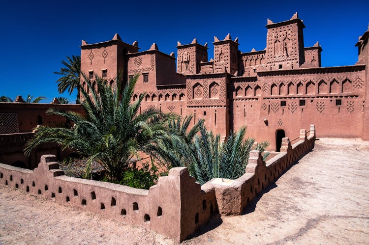 Ancient Desert Architecture with Green Palm Trees